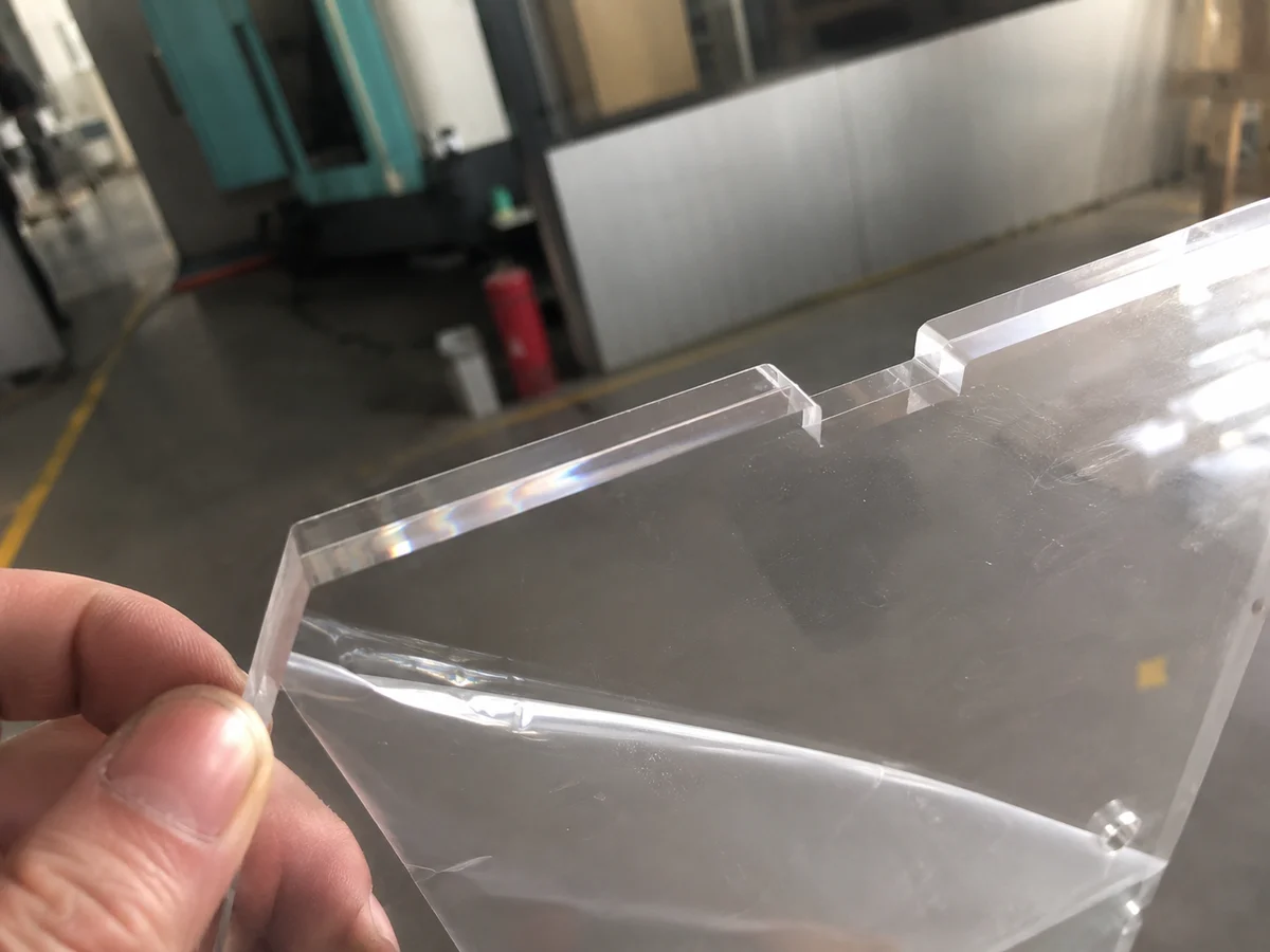 Clear acrylic CNC machined part with polished edge and protective film