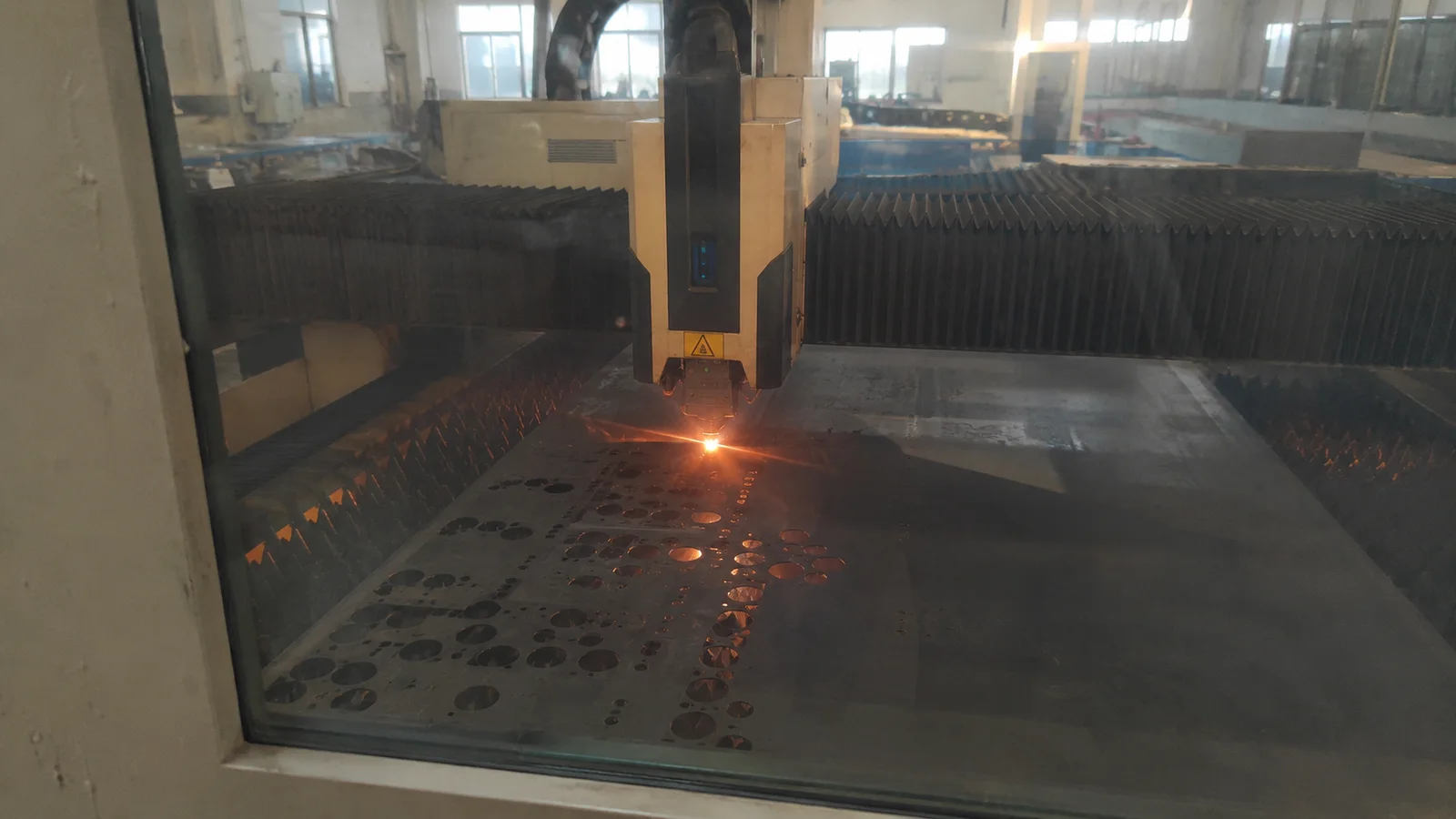 Laser cutting machine cutting sheet metal parts in a factory