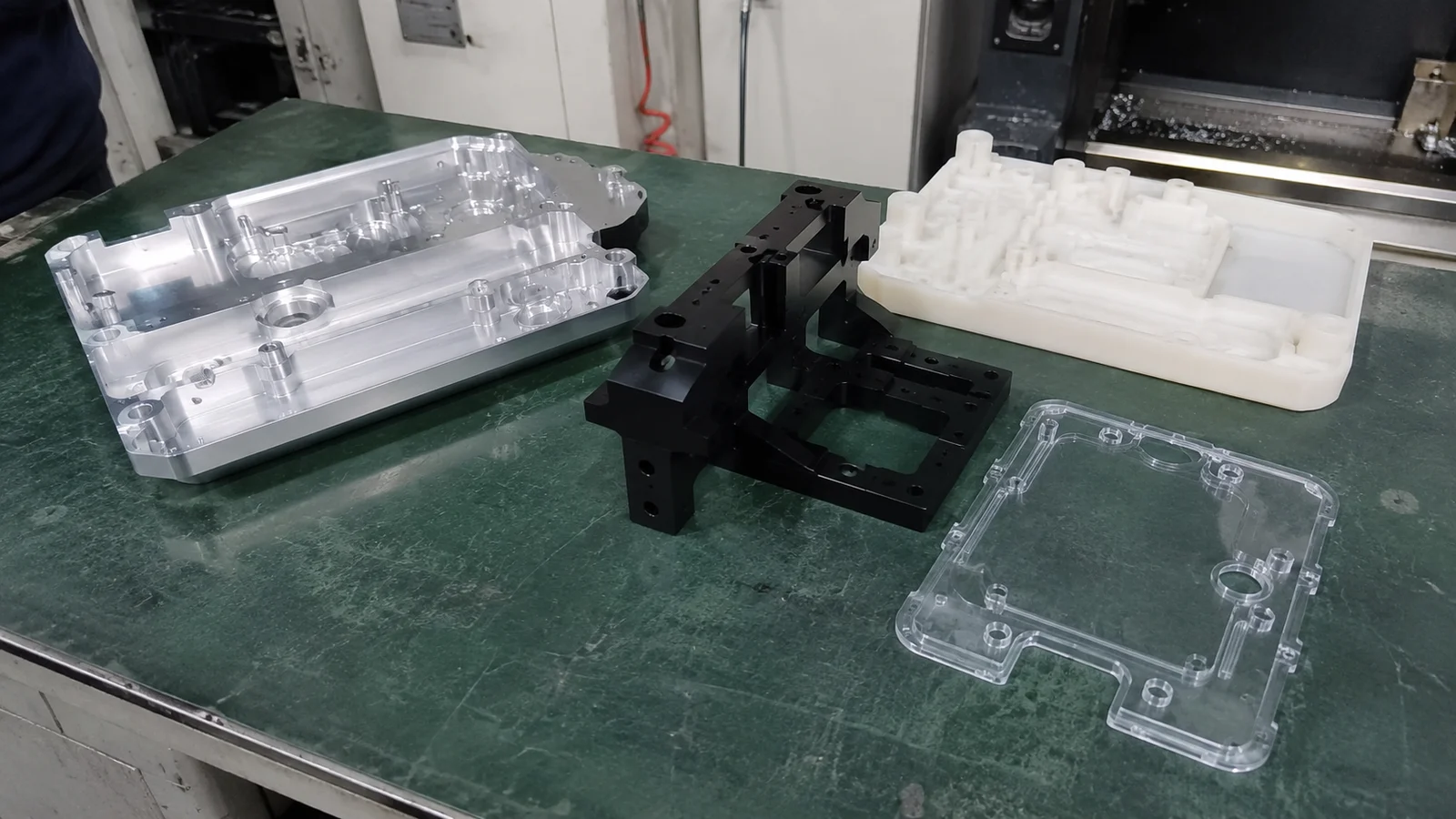 Finished CNC 3D printed and acrylic prototype parts on factory bench
