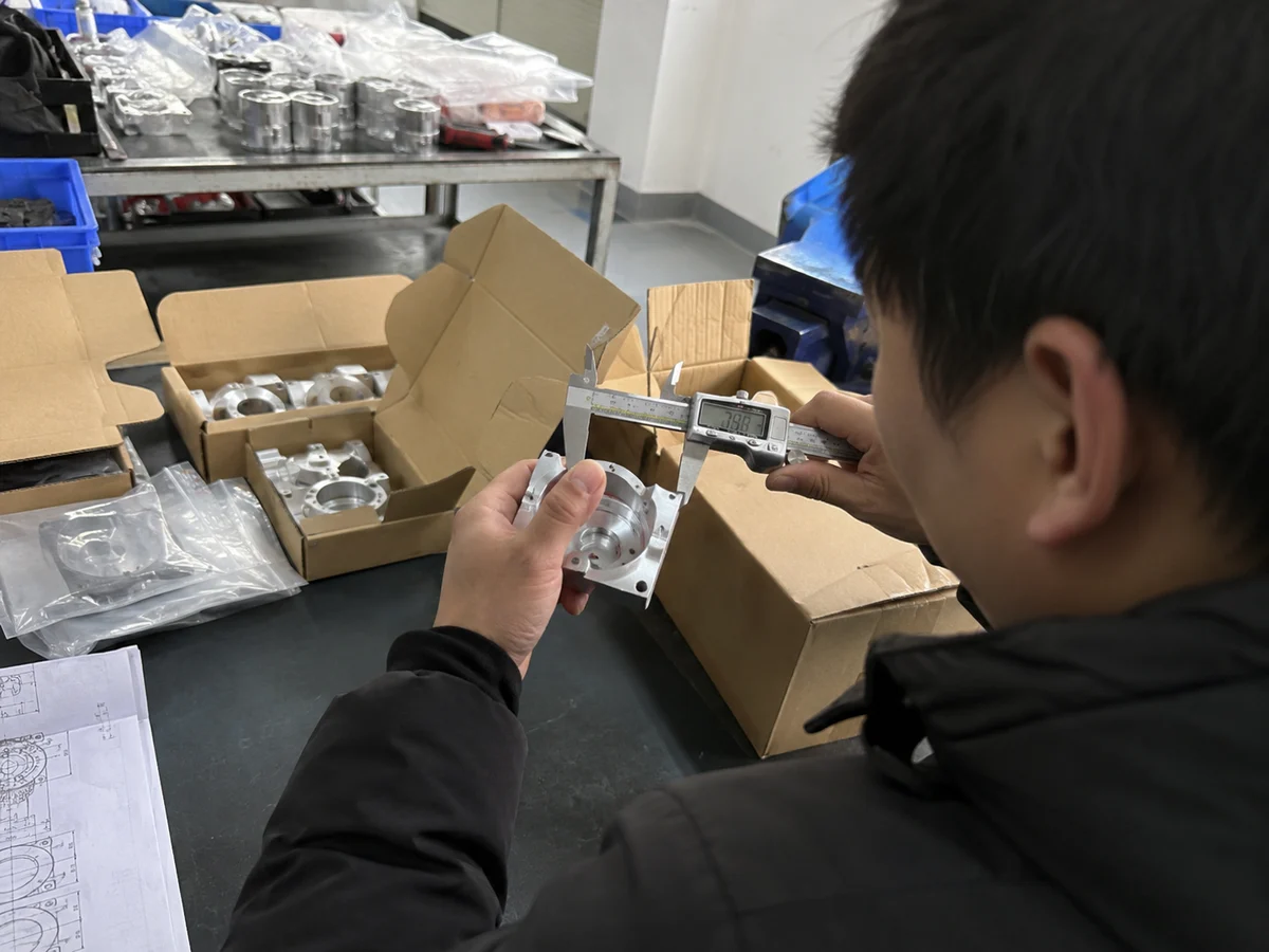 Inspector checking machined prototype before shipment